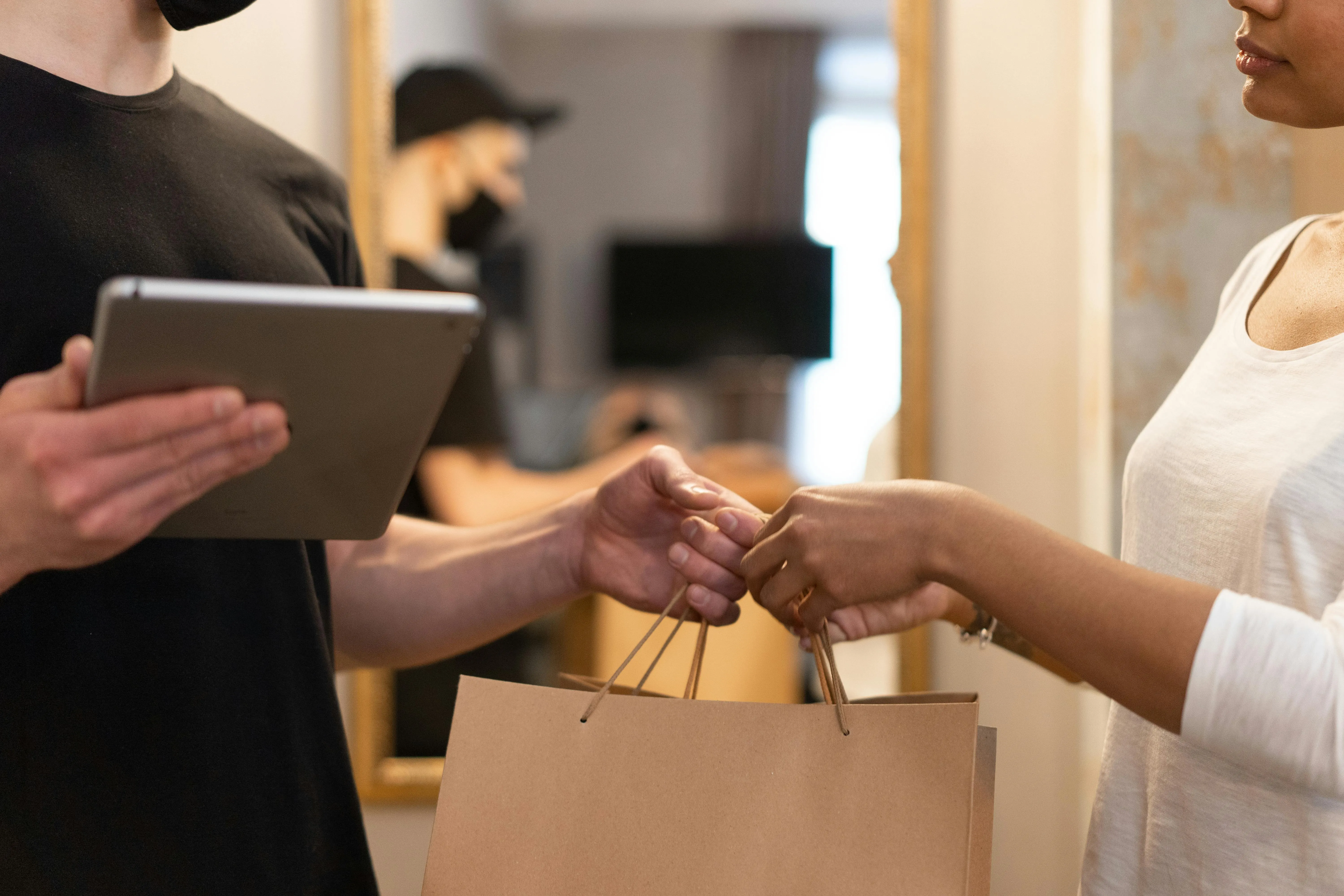 Entrega de sacola de compras entre duas pessoas.