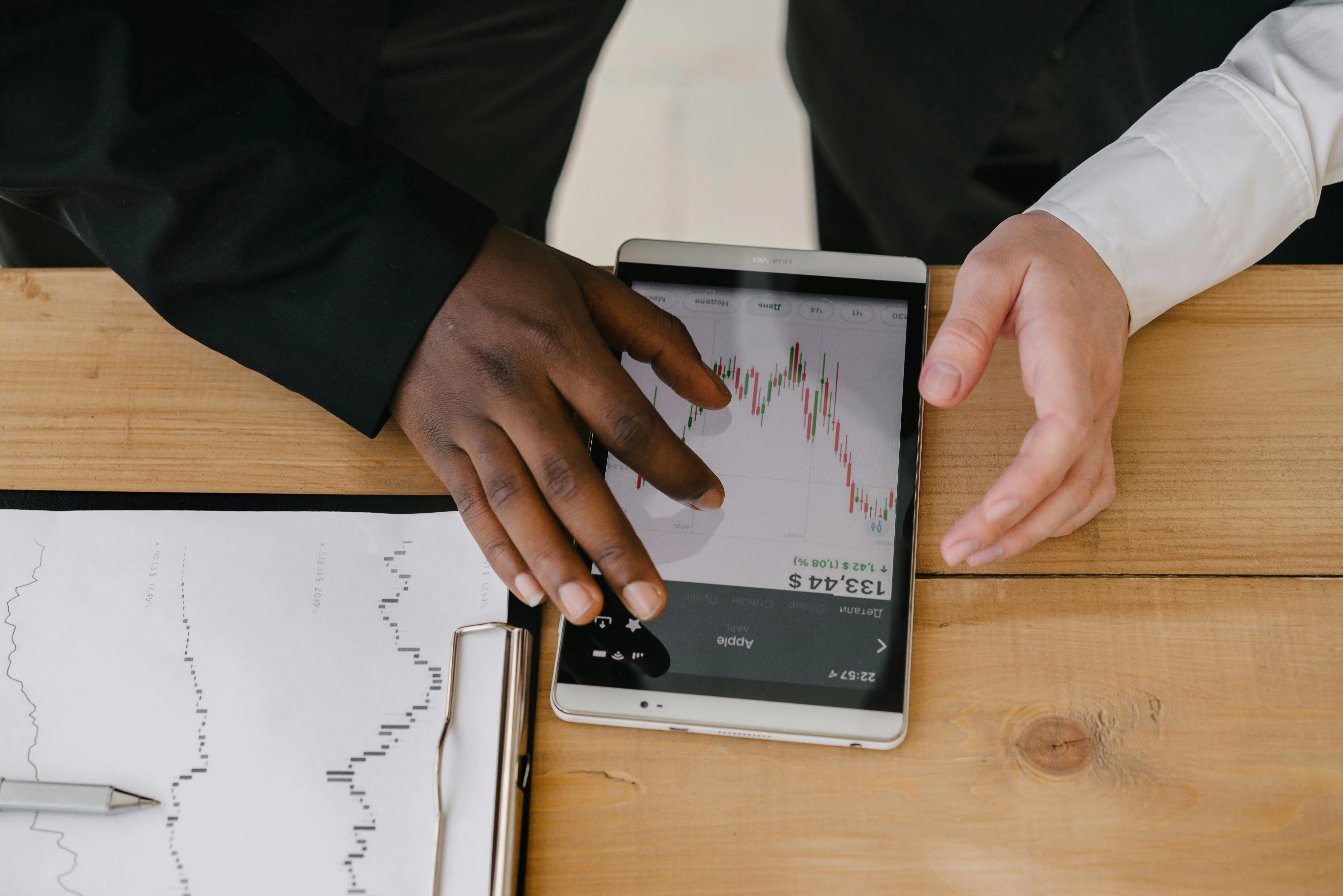 #FotoDescrição: Duas pessoas analisando gráficos em um tablet, representando análise de dados com IA.