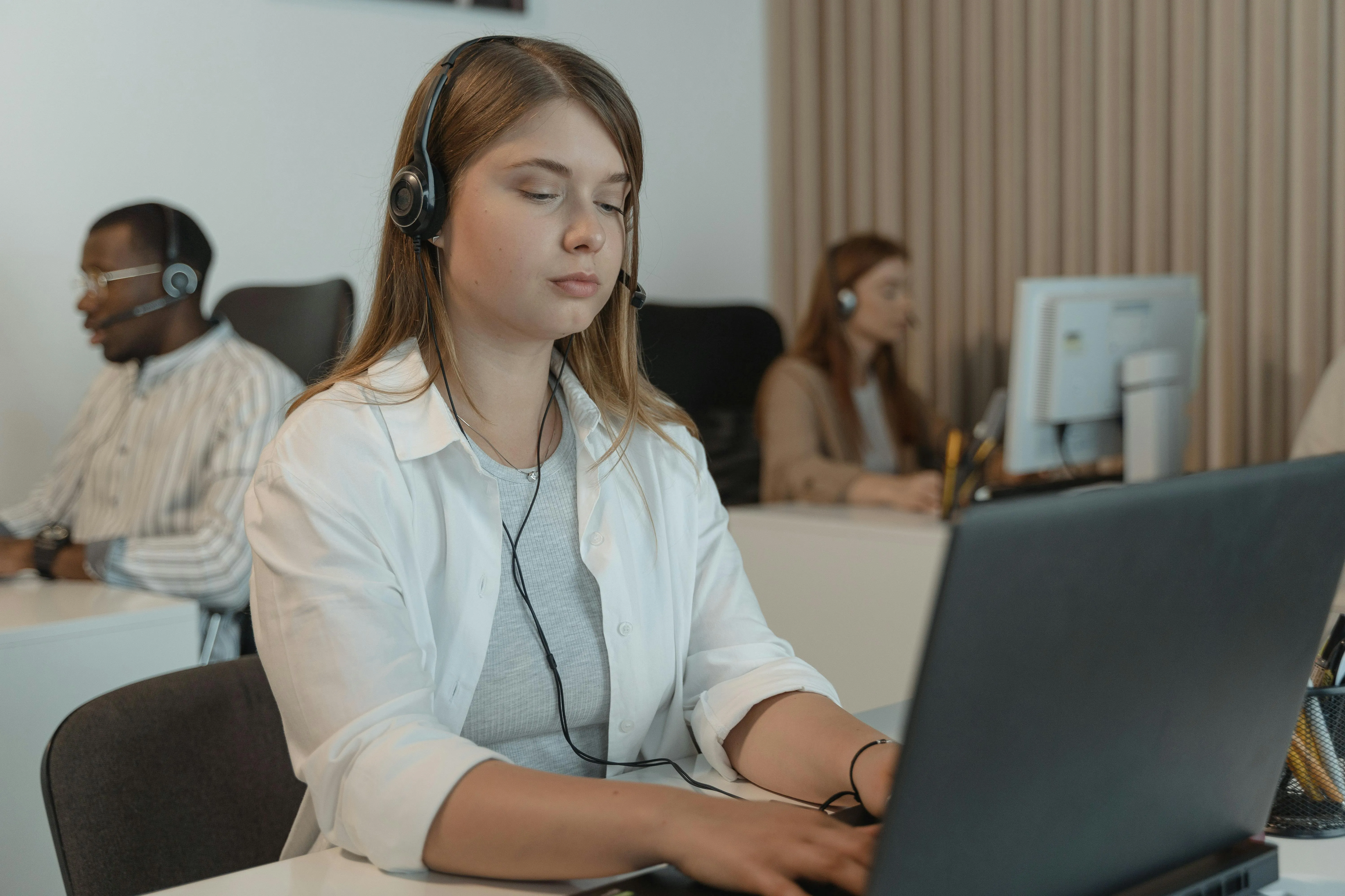 #FotoDescrição Mulher com headset trabalhando no atendimento ao cliente.