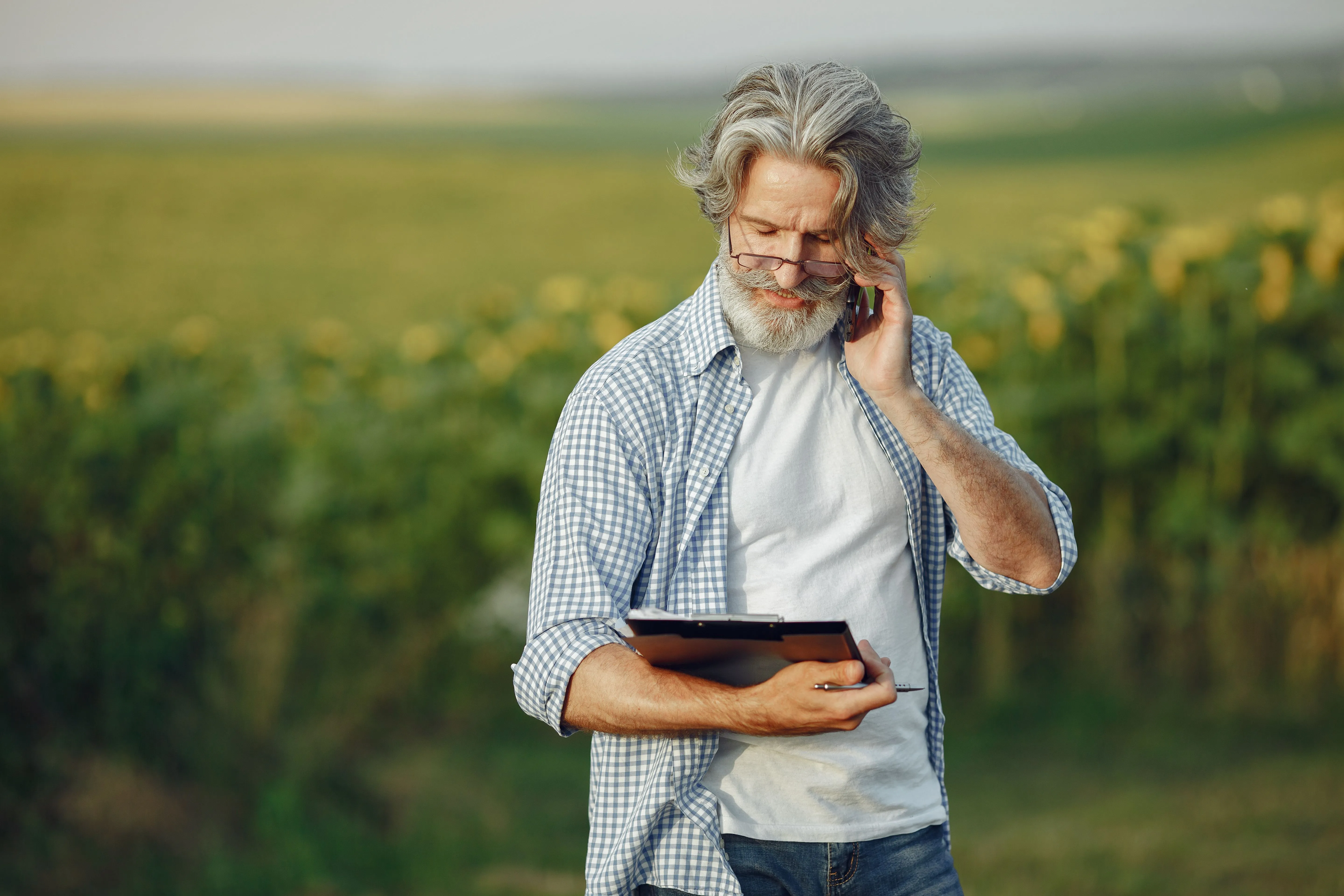 Produtor rural consulta dados em tablet durante vistoria na lavoura