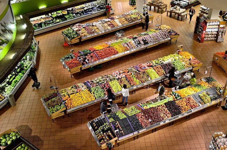 #FotoDescrição: Vista aérea de um supermercado com seções organizadas de frutas e vegetais, destacando a variedade de opções.