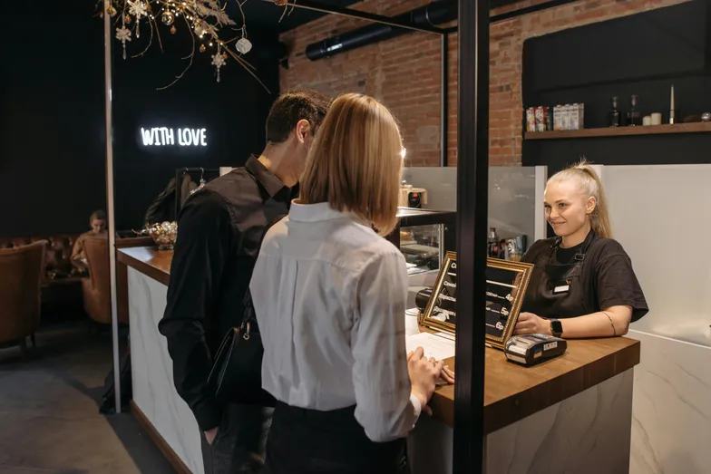 Cliente paga atendente em café moderno no balcão