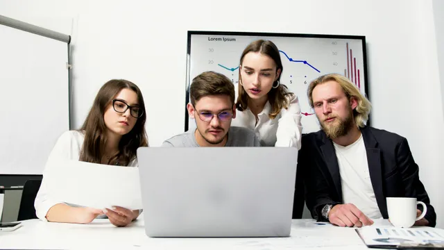 #FotoDescrição: Equipe analisando dados e gráficos em um laptop, discutindo estratégias para fortalecer a marca.