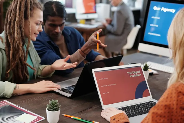 Equipe discutindo estratégias digitais com notebooks em uma reunião.