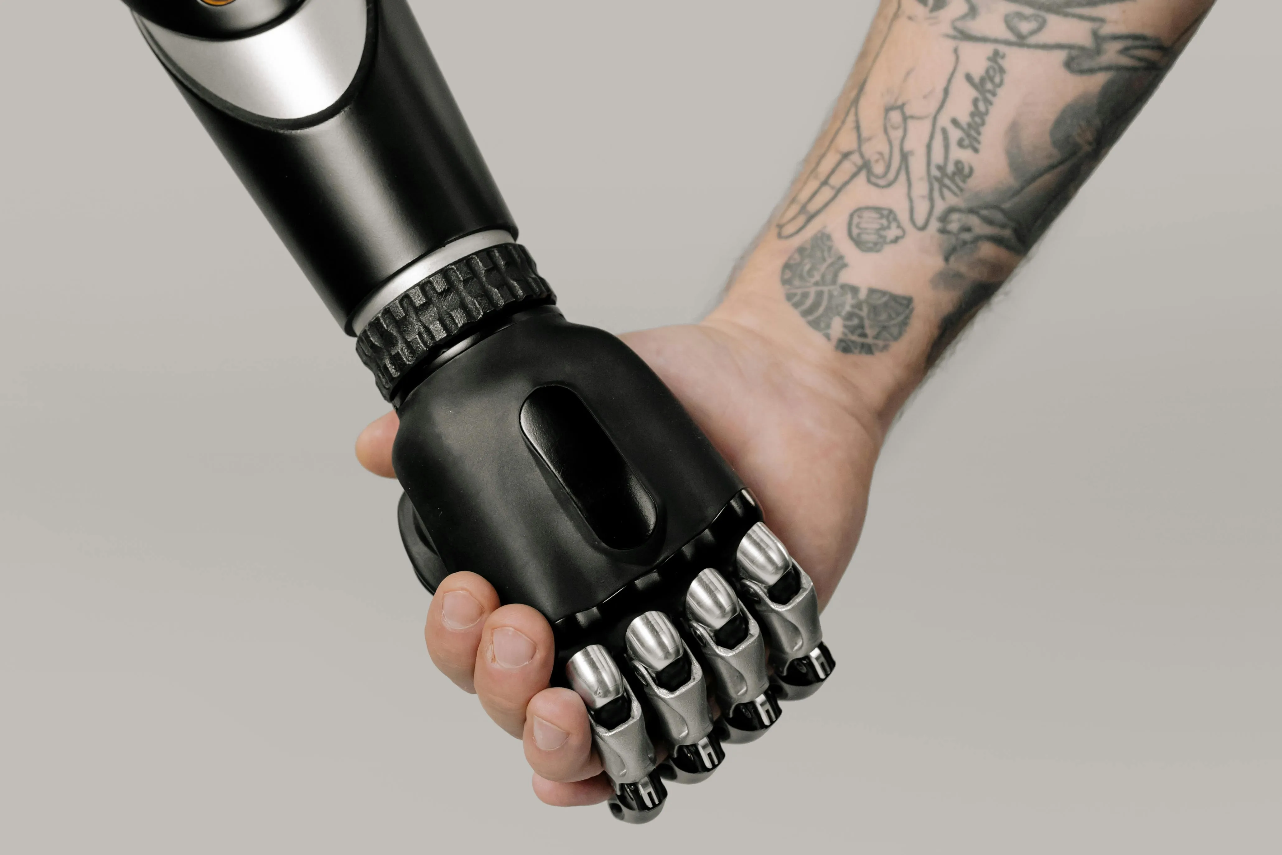 Mão humana segurando mão robótica, simbolizando parceria e inovação tecnológica.