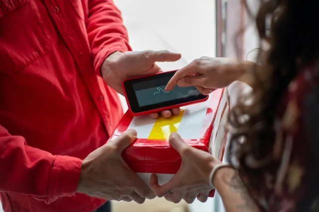 Cliente assinando entrega em dispositivo eletrônico