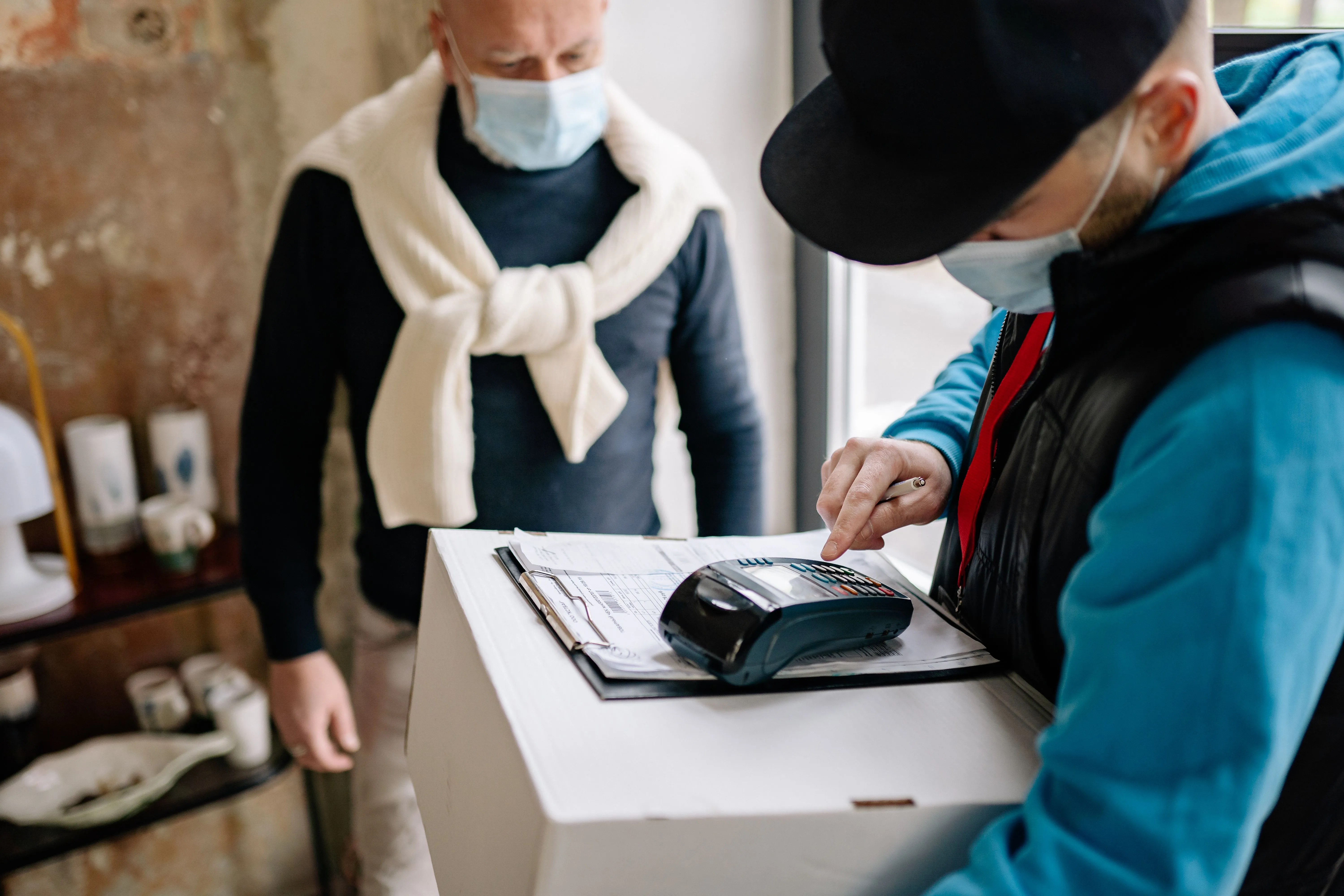 Entregador registra pagamento em máquina de cartão durante entrega