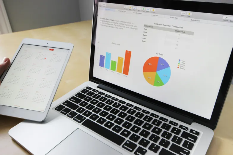 Gráficos e dados financeiros exibidos em laptop e tablet