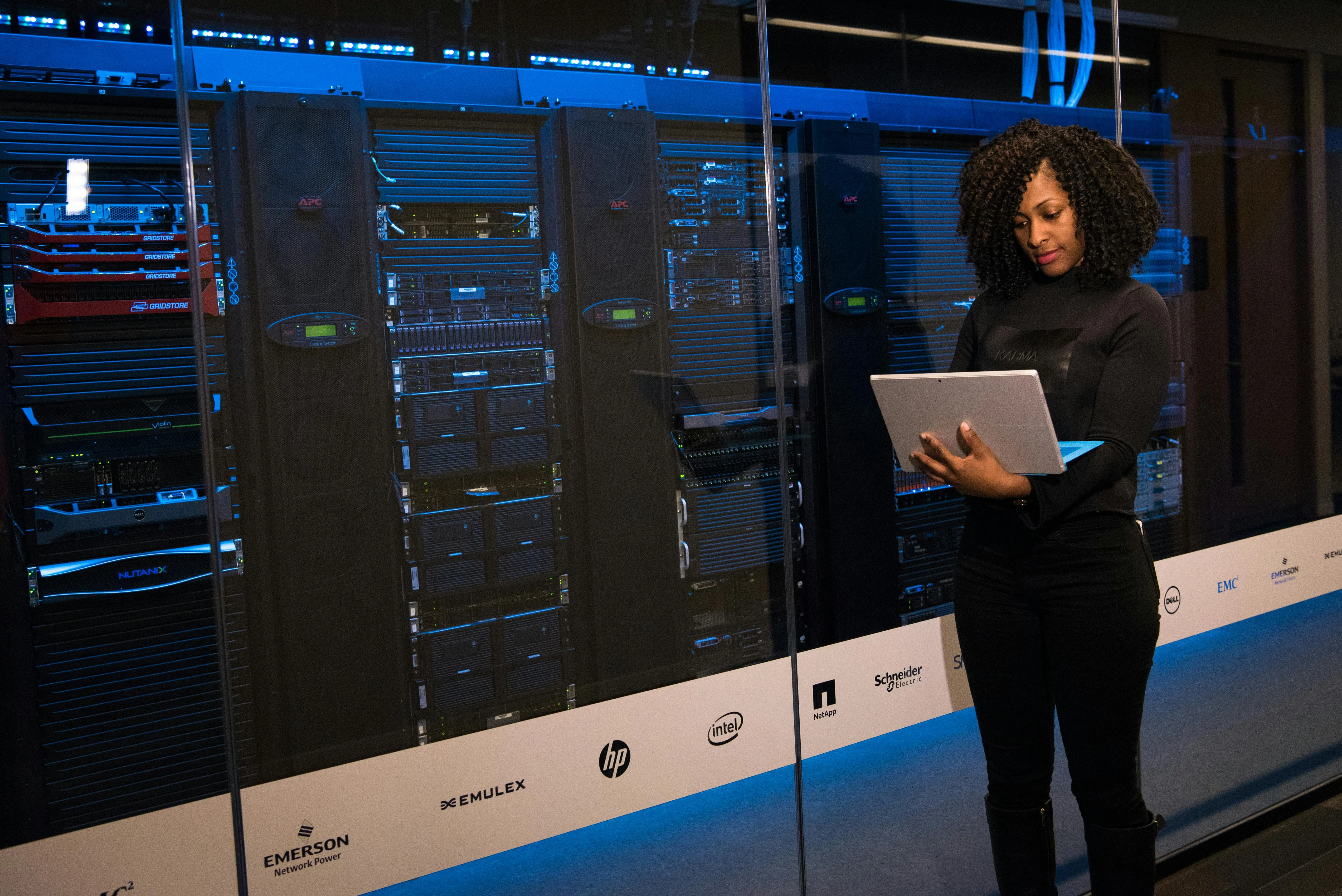 Profissional analisando equipamentos de servidor em data center, foco em rede e tecnologia.